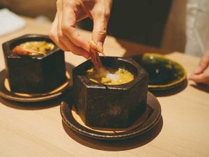 鮑肝ソースが絡む毛蟹と鮑の熱々御石