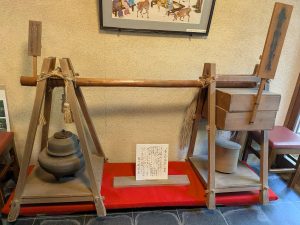 昭和2年に復元された天秤棒が店内に展示されています。左に火を起こす茶釜、右下に茶筒、幹上の箱に餅菓子を入れて担いでいました