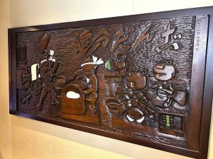 店舗奥の喫茶室では創業当時に作られた木彫りの作品があり、温かみと老舗の雰囲気が漂う
