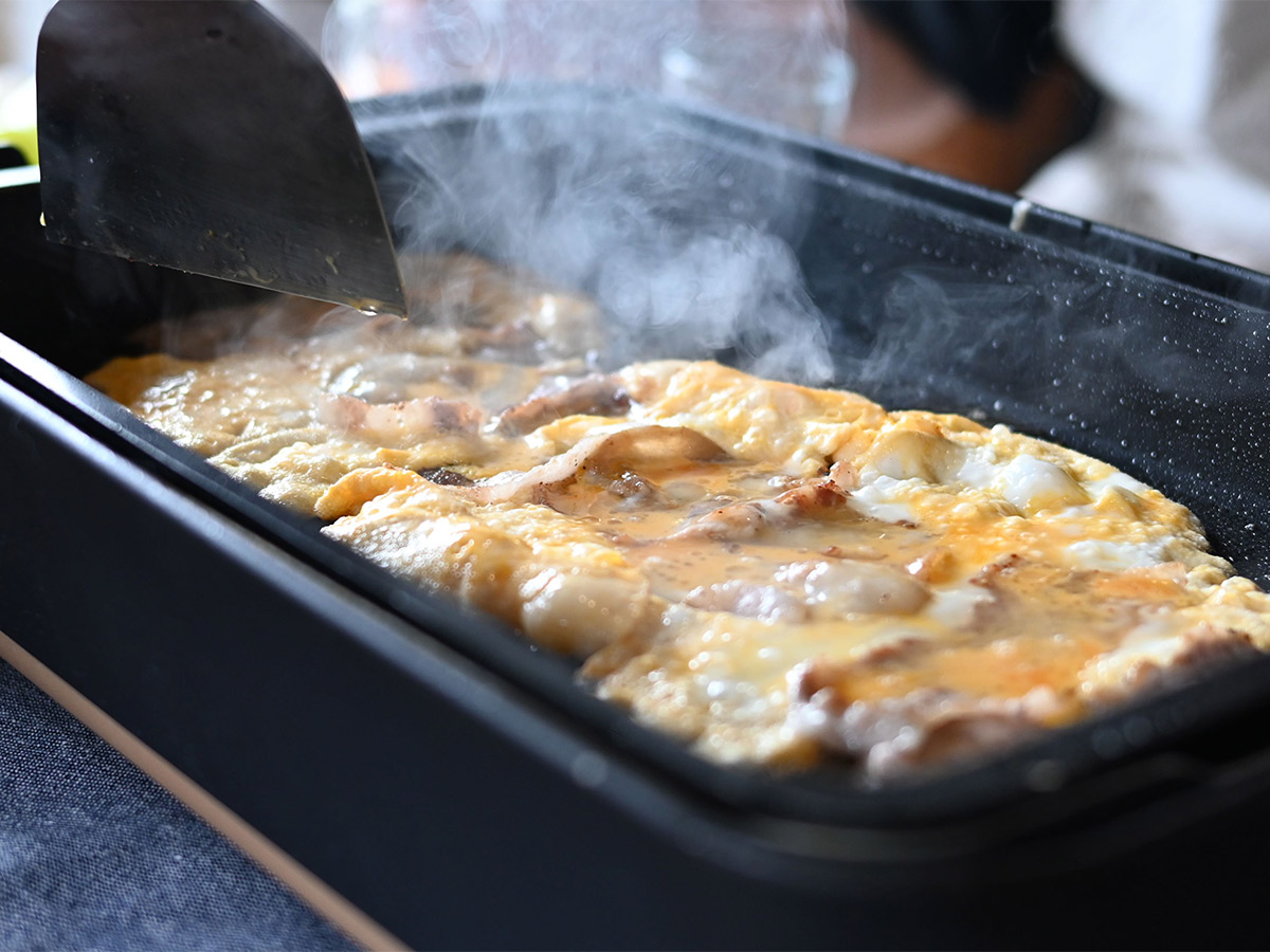 豚バラを焼き、豪快にとき卵を流し入れて作るとん平焼きは、あえてポン酢で食べるのが鈴木さん流。お酒に合う！