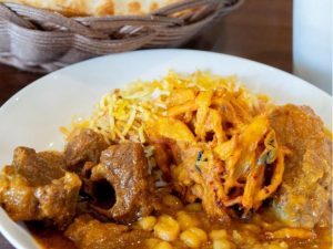 上から時計回りにチキンビリヤニ、チキンコルマ、ひよこ豆のカレー、マトンカレー、真ん中にあるのはミックスベジパコラ（野菜のかき揚げ）