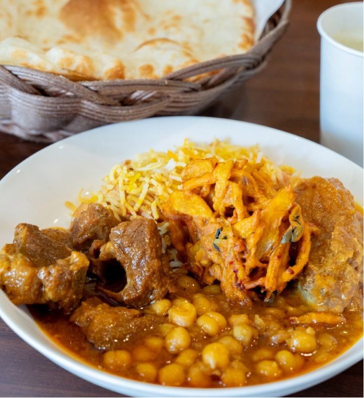 上から時計回りにチキンビリヤニ、チキンコルマ、ひよこ豆のカレー、マトンカレー、真ん中にあるのはミックスベジパコラ（野菜のかき揚げ）