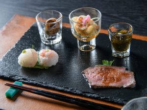 先付。左上から時計回りに、バイ貝、南蛮漬け、もずく酢、若狭牛のローストビーフ、手鞠寿司