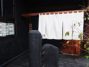 白い暖簾がはためく店頭風景