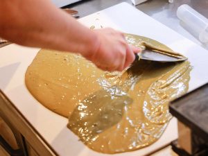 ほうじ茶の板チョコの製造風景。テンパリングの前に、ほうじ茶パウダーをホワイトチョコレートに馴染ませる