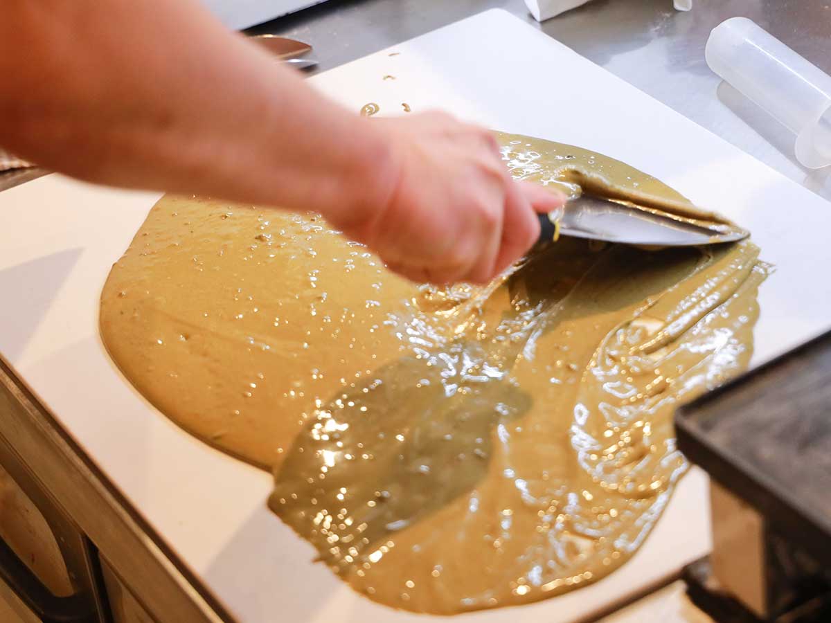 ほうじ茶の板チョコの製造風景。テンパリングの前に、ほうじ茶パウダーをホワイトチョコレートに馴染ませる