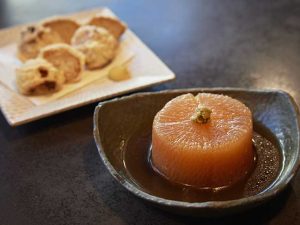 手前：「鴨だし煮大根」1,000円。鴨肉の出汁が芯までしみた一品。奥：「鳥だんご」1,000円