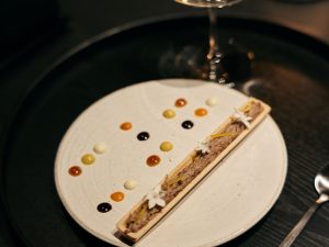 「視る」一皿。鴨のリエットは最中とともに。柚子の香りと白い花を添え、皿の上にはバルサミコや豆腐、味噌、人参など5種類のソースをドット状に配置。味の組み合わせを探りながら食べ進める楽しさがあります