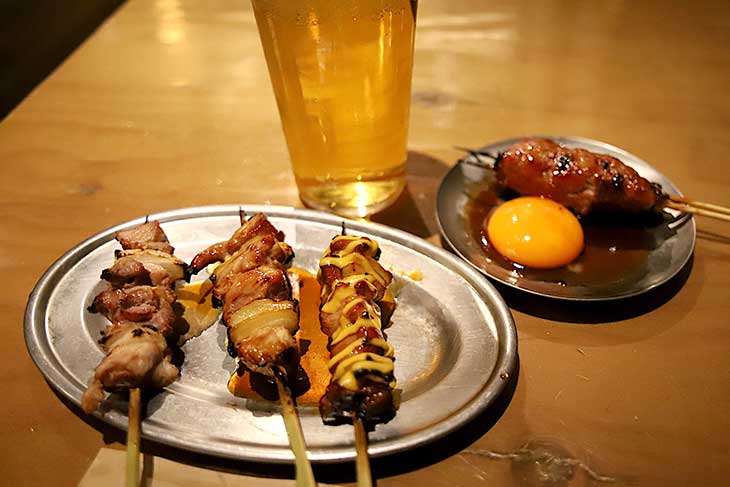 手前:純けいもも串 各180円、奥:純けい生つくね月見 250円、ビール 490円